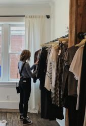 Person browsing clothes in a cozy room with a teepee and a bright window near LOCAL Boise apartments.