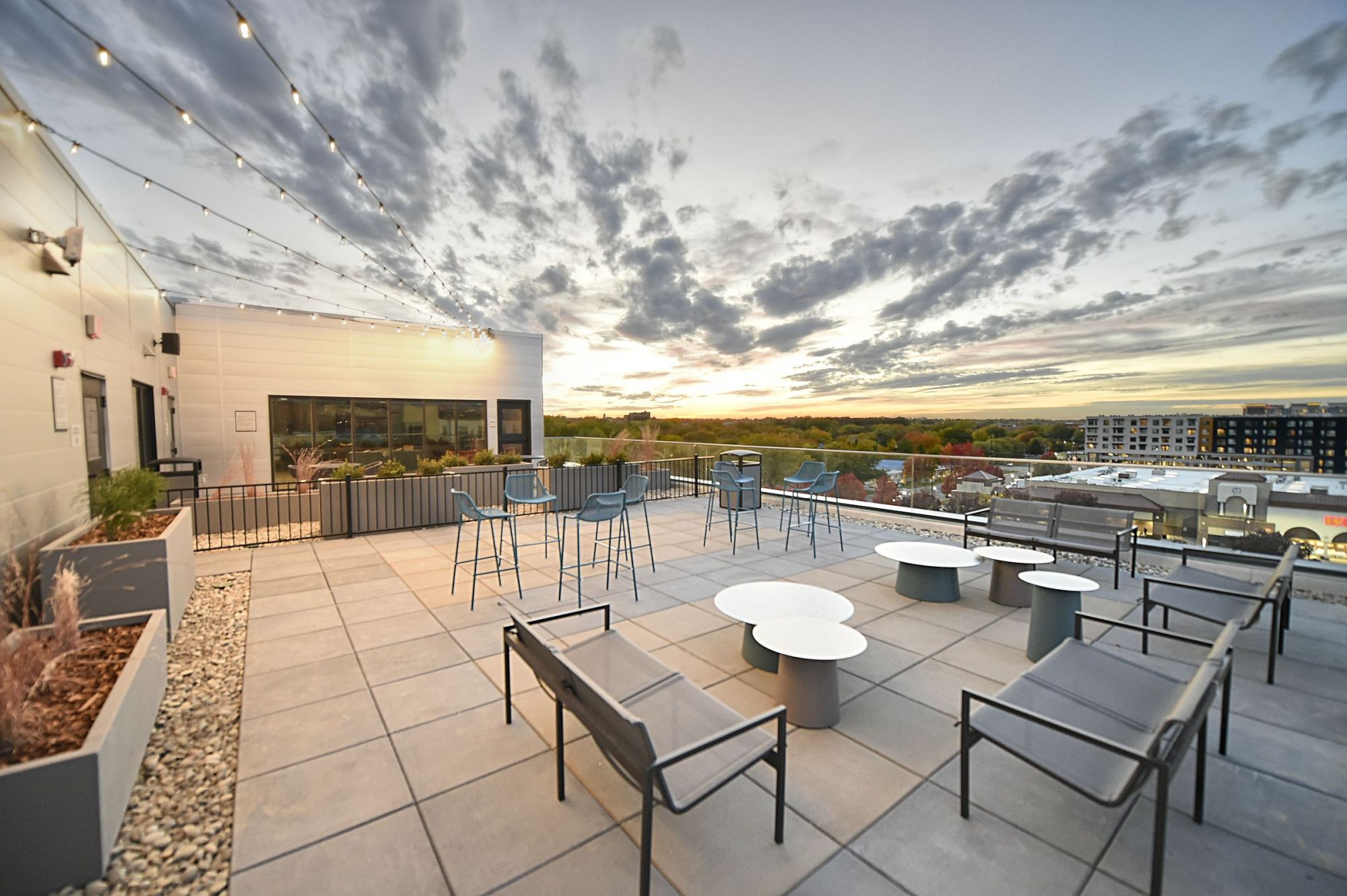 LOCAL Boise Apartments roof deck with tables, chairs, and scenic city views