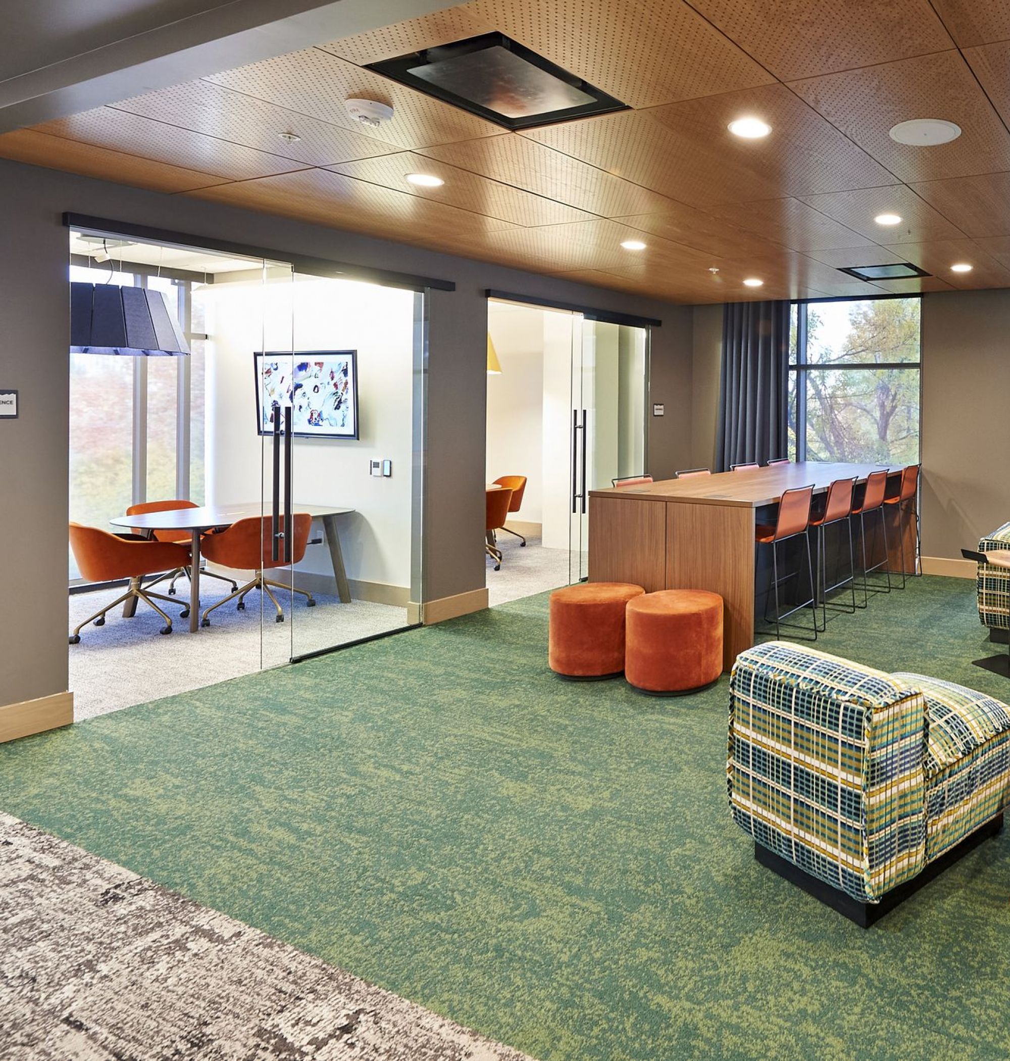 LOCAL Boise Apartments co-working-inspired club room with comfortable seating, shared workstations, colorful furnishings, and private conference rooms