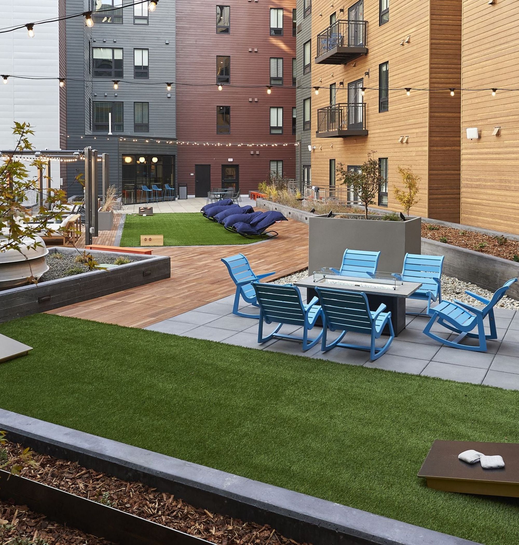 LOCAL Boise Apartments outdoor courtyard with string lights, ample seating, and lawn games