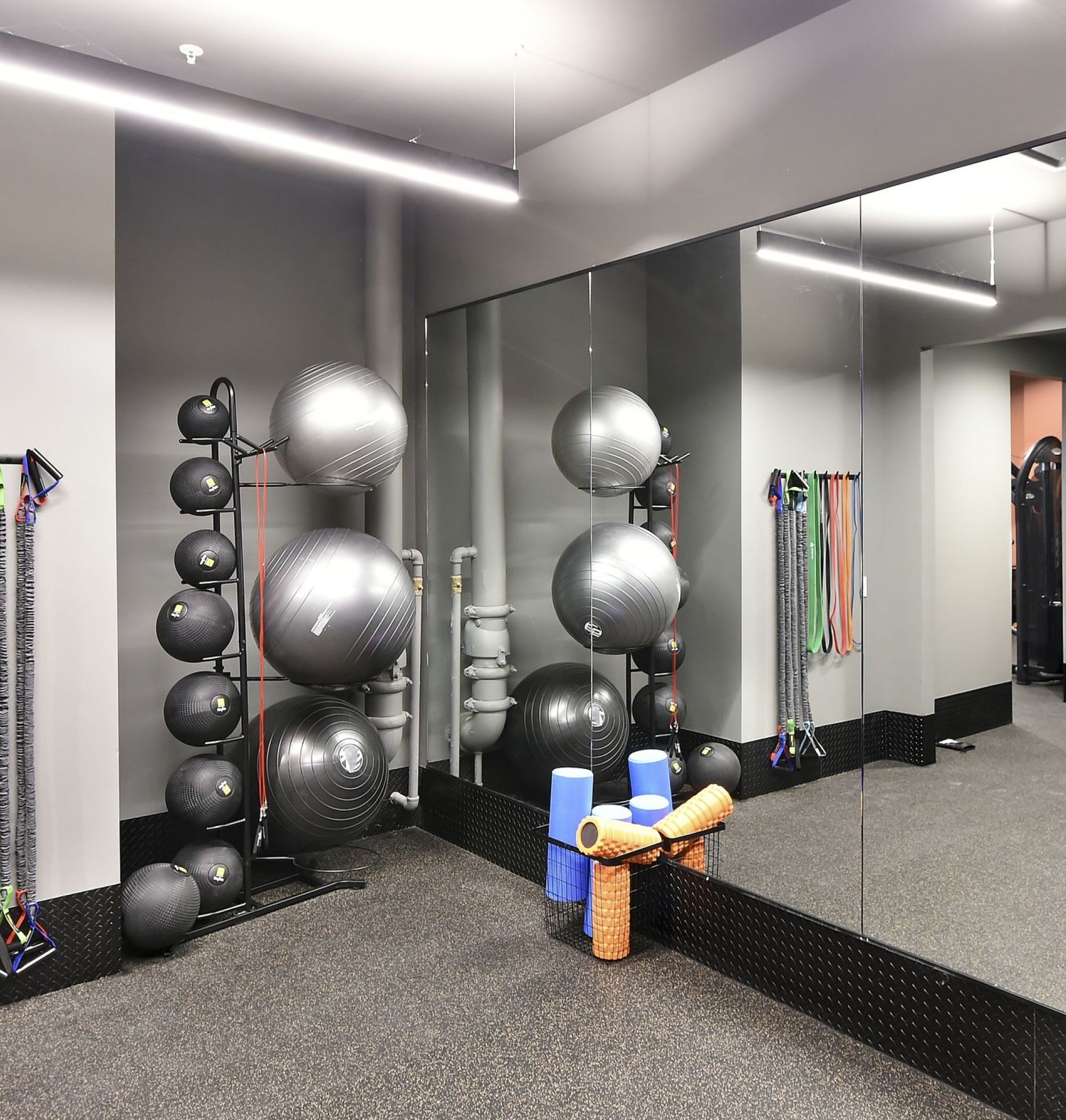 LOCAL Boise Apartments HIIT and Yoga room with large mirrors on the wall, and fitness equipment next to empty floor space